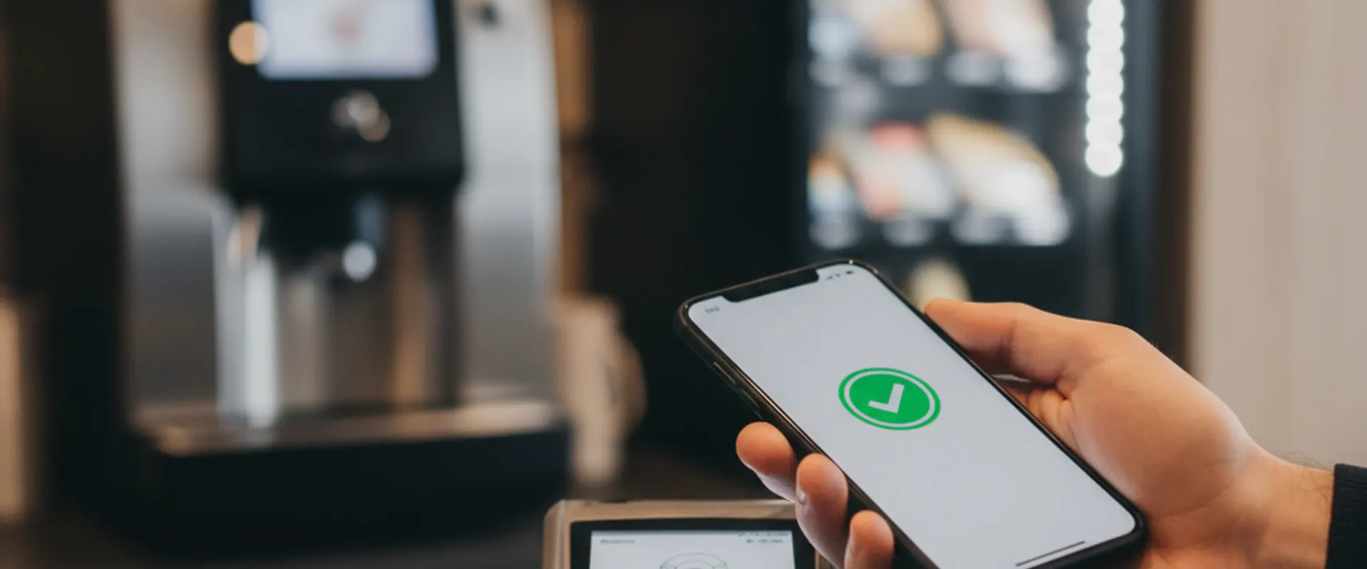 Kontaktlose Bezahlung per Smartphone an einem NFC-Terminal im Betrieb